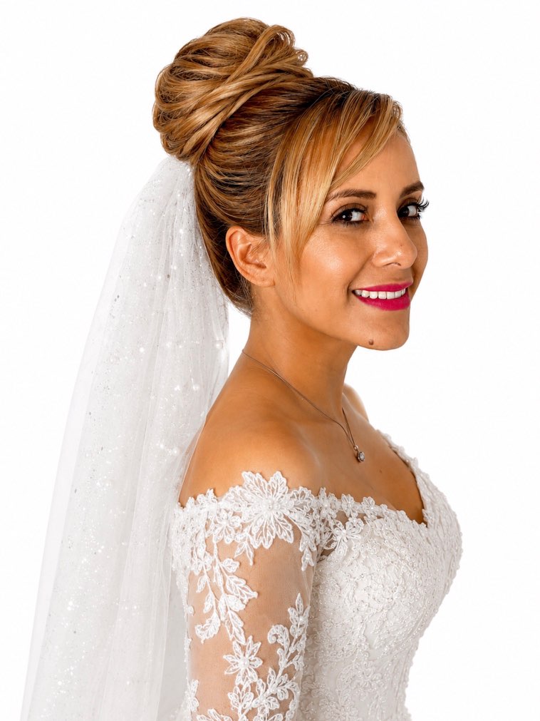 Bridal styling with a highlighted high bun and a delicate veil